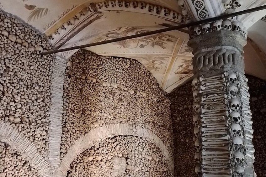 Un techo con diseños elaborados y una columna decorada con calaveras. 1