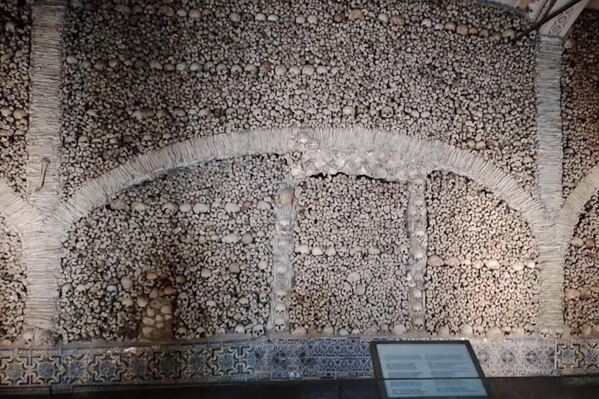 Un muro de piedra con intrincados grabados y un cartel. 4