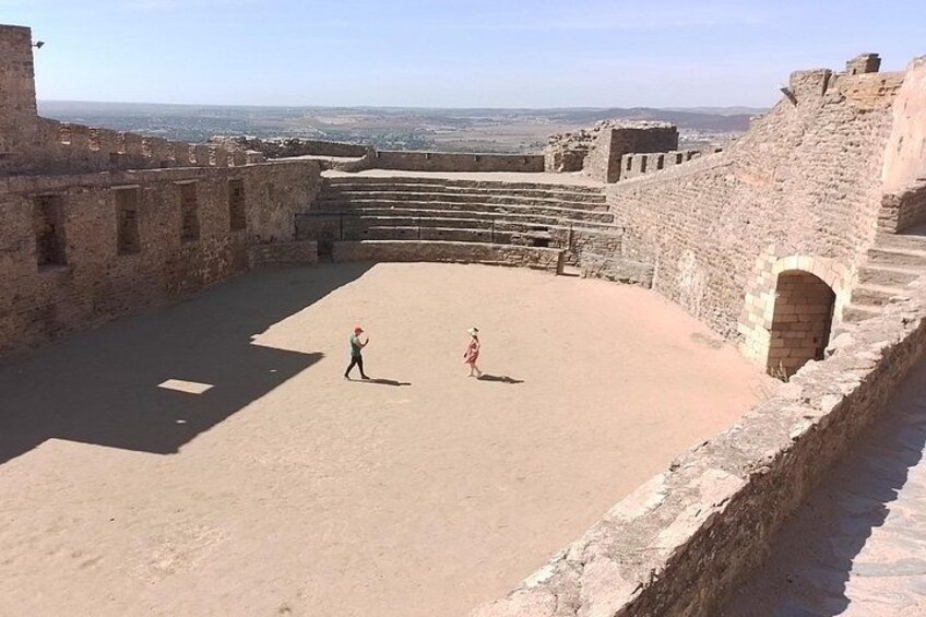 Un antiguo anfiteatro con escalones de piedra y una zona de actuación plana. 4