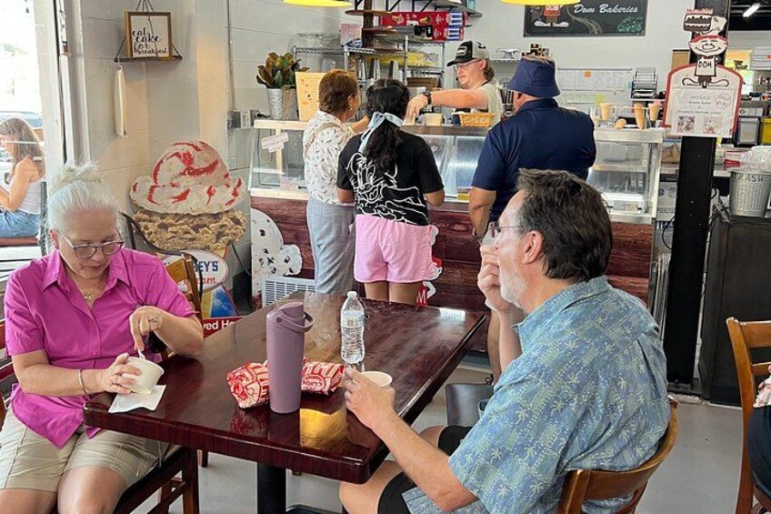 Un restaurante con mostrador, tablero de menú y una vitrina de postres. 2