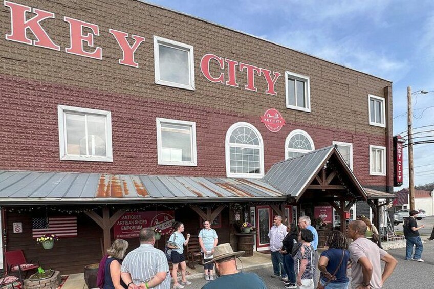 Un edificio de ladrillo con un letrero que dice 'KEY CITY' y un escaparate con un porche cubierto. 5