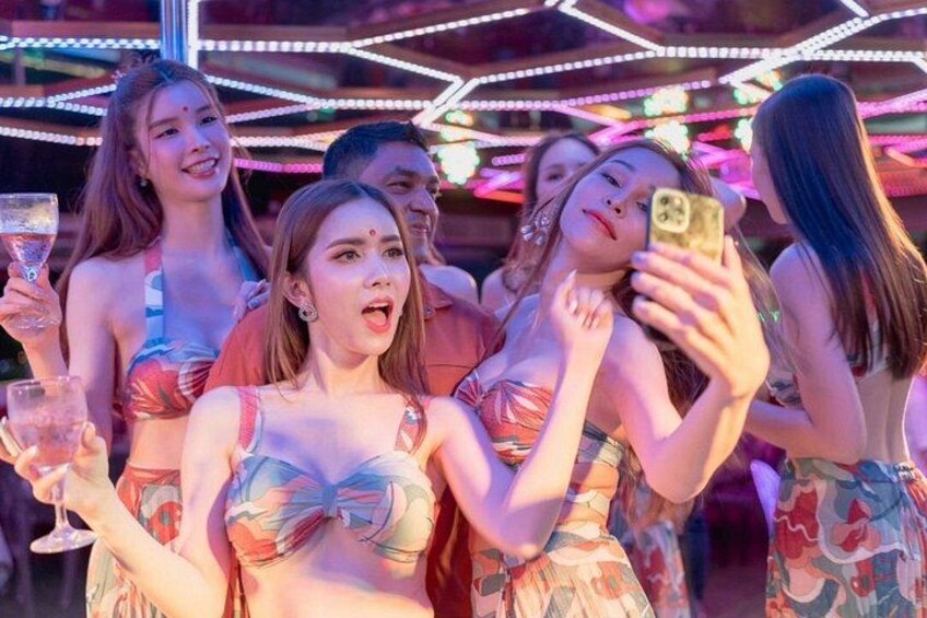 A group of people at a brightly lit venue with neon lights. 4