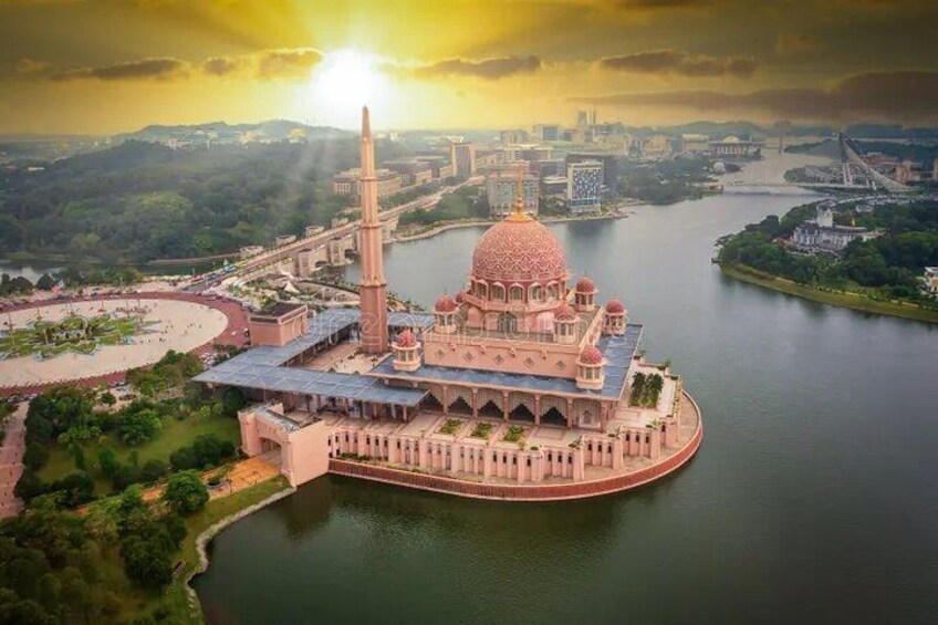 A large, domed building with a tall minaret, surrounded by water and greenery. 2