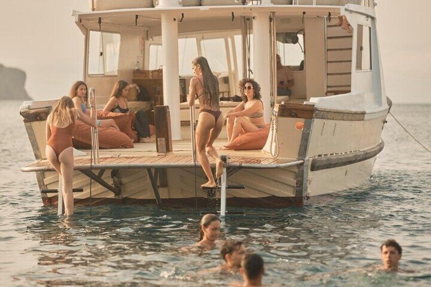 Ein Boot mit Personen auf dem Deck und im Wasser. 2