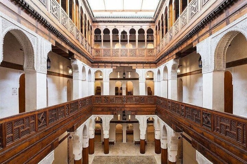 A courtyard with arches, wooden railings, and a central open space. 2