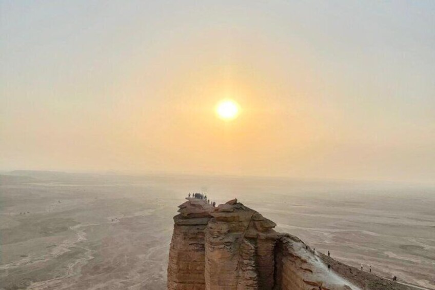 A desert landscape with a rock formation and a sunset in the background. 5