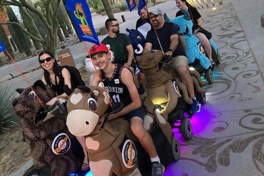 People riding animal-shaped vehicles with lights. 2