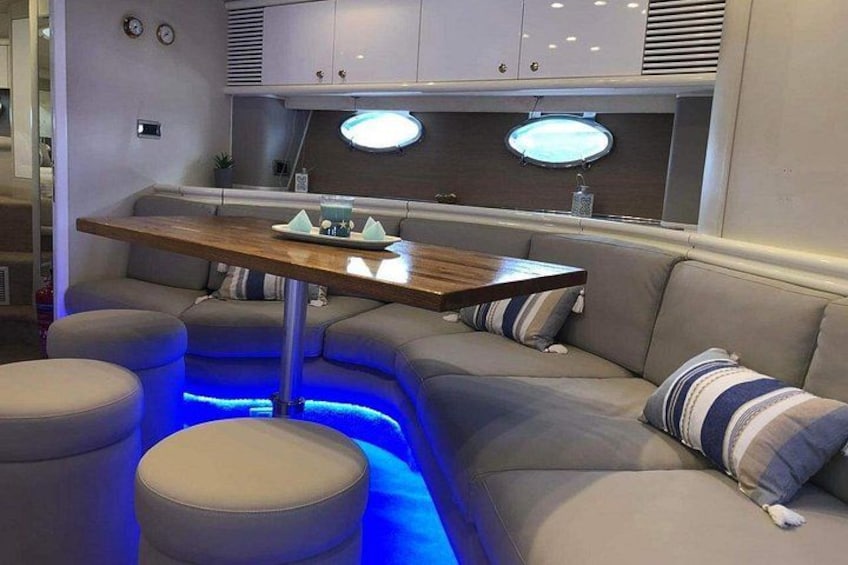 A cozy interior with a curved sofa, a wooden table, and blue ambient lighting. 5