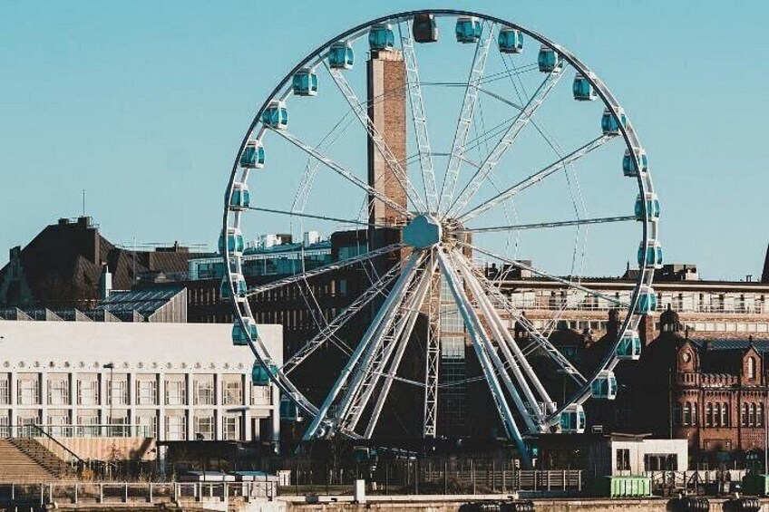 A large Ferris wheel with gondolas, a tall building, and a historic building with arched windows. 3