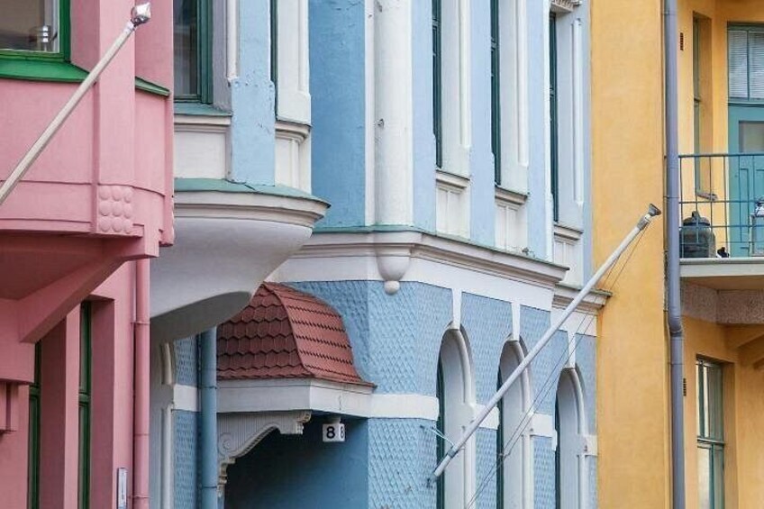 A colorful building with a red roof, blue and white trim, and a balcony with a railing. 4
