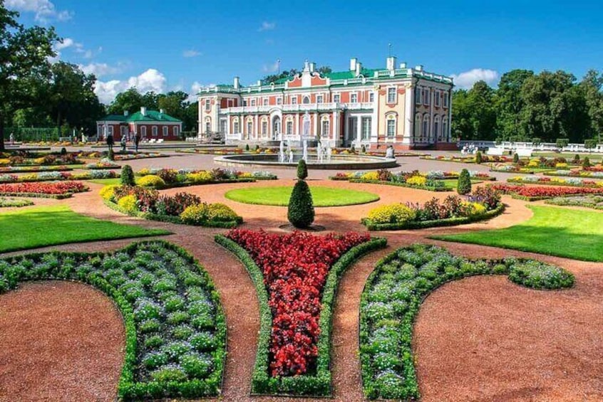 Un imposant bâtiment agrémenté d’un jardin à la française devant l’entrée. 5
