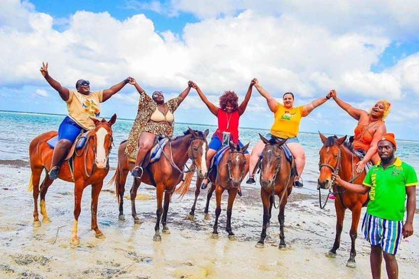 A group of people on horses at the beach. 1