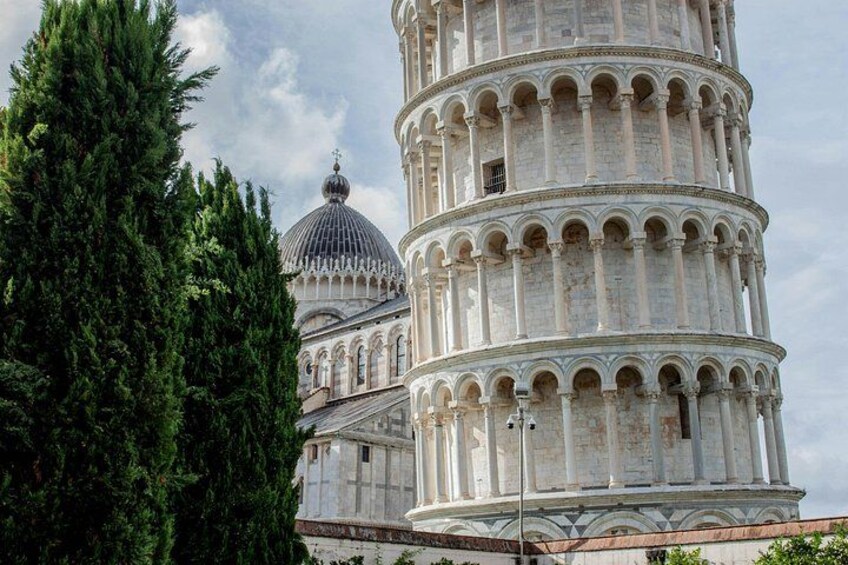 The Leaning Tower of Pisa with a dome in the background. 4