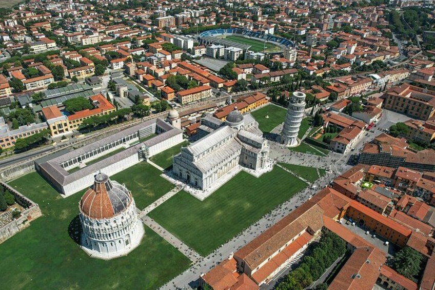 An aerial view of a historic city with prominent architecture, including a large dome and a leaning tower. 3