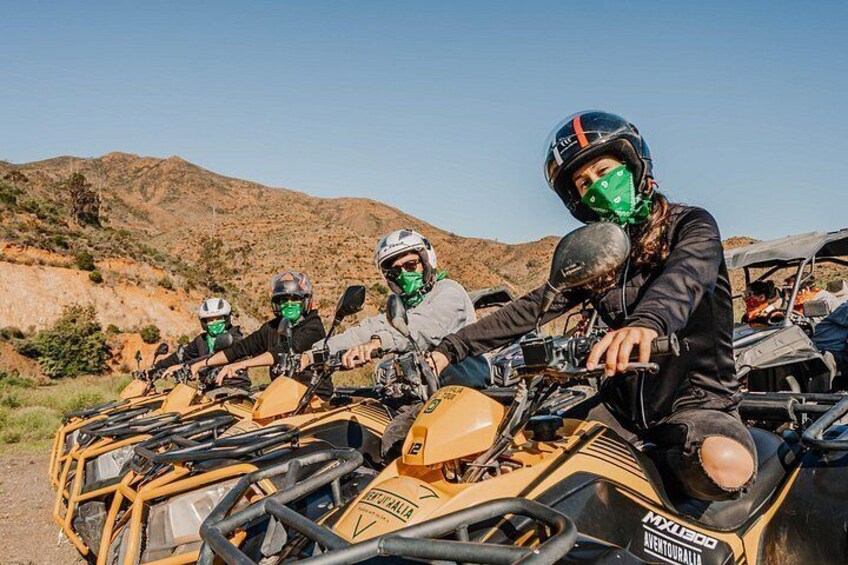 Un groupe de personnes conduisant des quads dans un paysage désertique. 1
