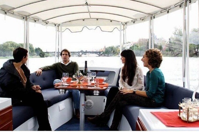Un grupo de personas en un barco, con una mesa dispuesta para una comida. 3
