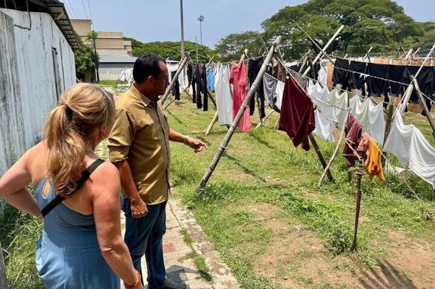 A man and a woman observing a clothesline with various garments hanging. 5