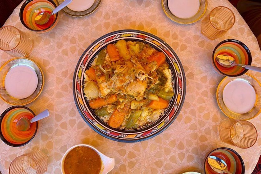 Une table sur laquelle se trouve un grand bol rempli de ragoût, entouré de tasses colorées et d’une carafe. 4