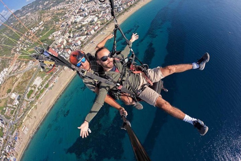 Eine Person mit Fallschirmsprung über einer Küstenregion mit Gebäuden und einem Strand. 2