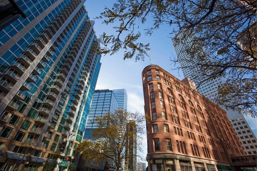 Un paisaje urbano con edificios altos modernos, uno con fachada curva y otro con diseño de cuadrícula. 1