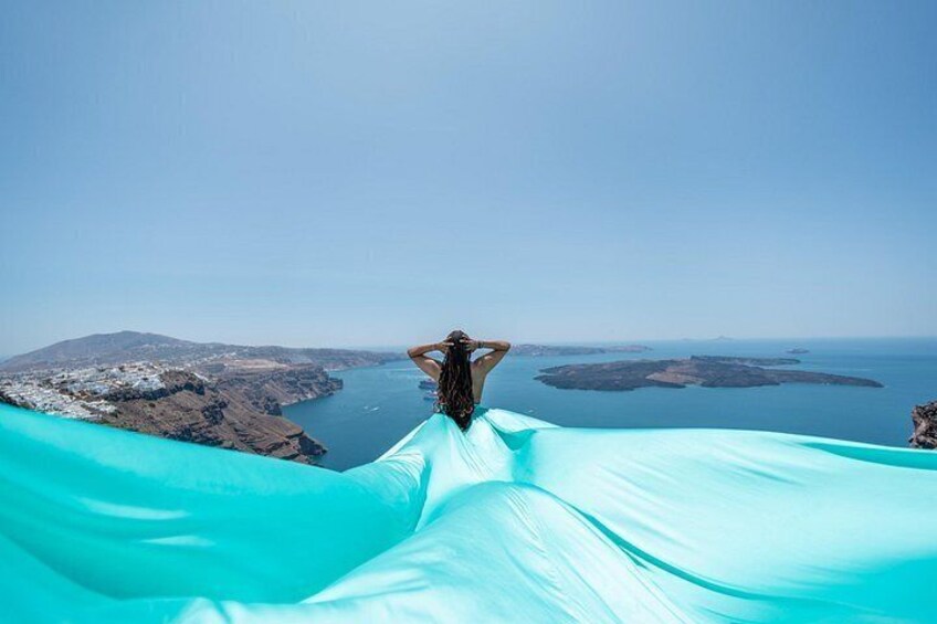 A person lying on a blue fabric with a scenic view of a coastline and islands. 4