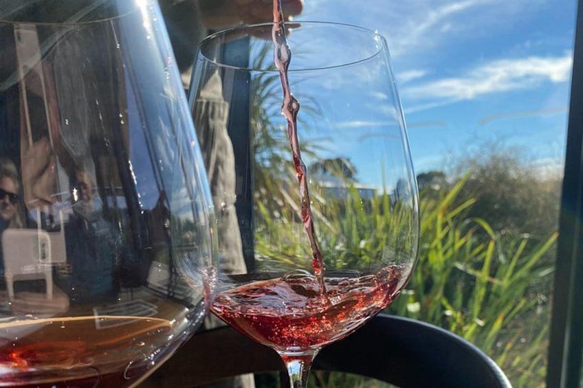 A glass of red wine being poured. 1