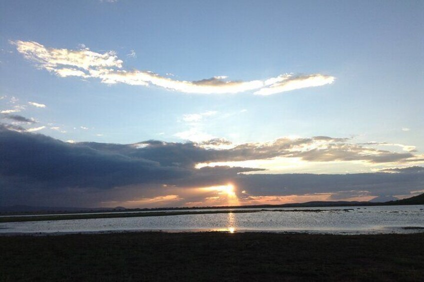 A sunset over a beach with clouds reflecting on the water. 2