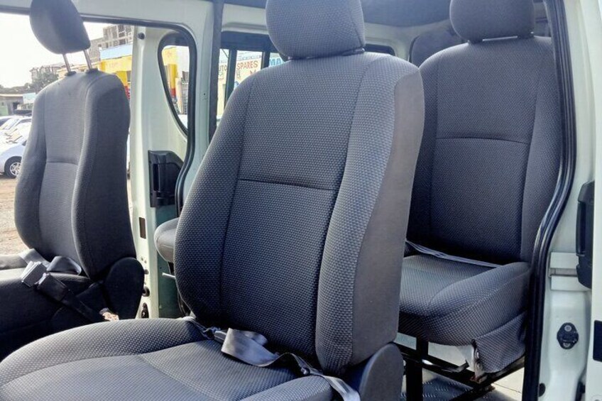 The interior of a vehicle with three rows of seats, each with a headrest and seatbelt. 3