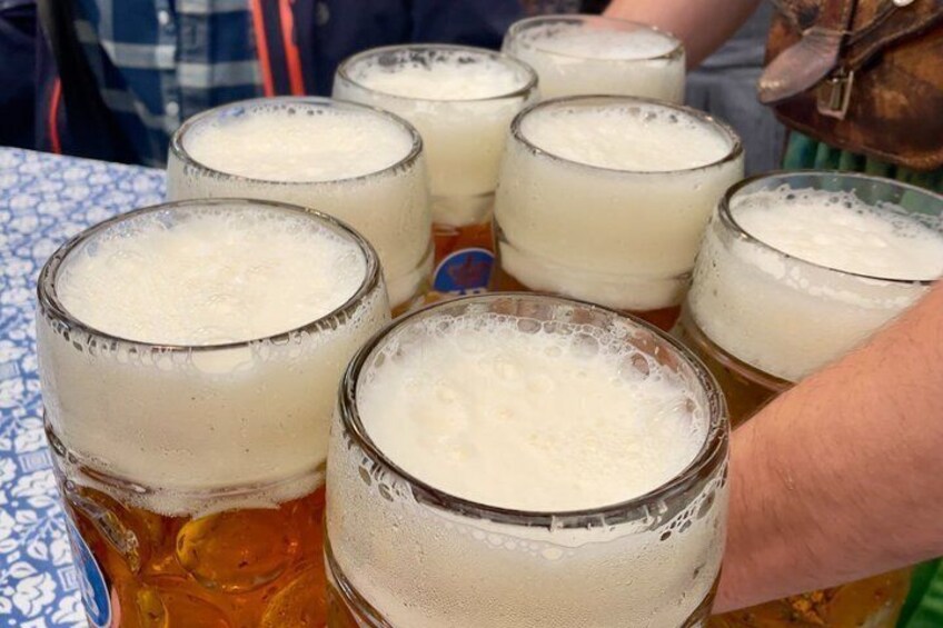 Une personne tenant une grande chope de bière mousseuse. 4