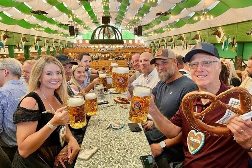 Un groupe de personnes participe à un festival de la bière, tenant de grandes chopes et des bretzels. 1