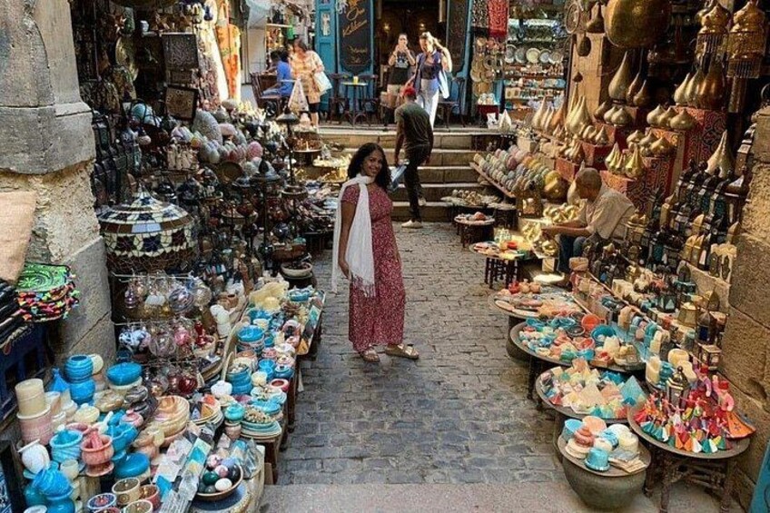 A narrow market street with various stalls selling pottery and ceramics. 2