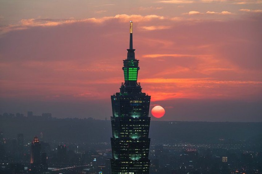 Stadsbeeld met een opvallend wolkenkrabber, verlicht tegen een zonsondergang. 5
