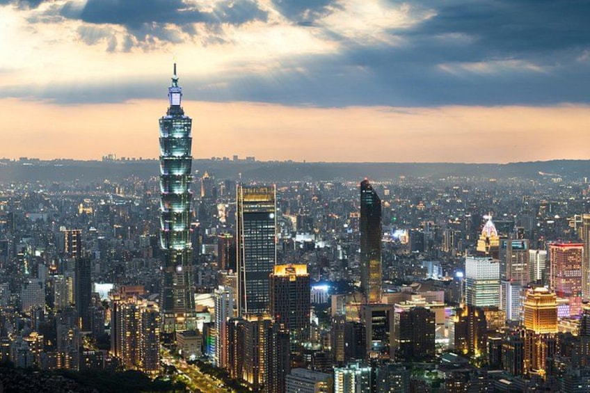Un paisaje urbano con una torre destacada, numerosos edificios altos y un cielo nublado. 1
