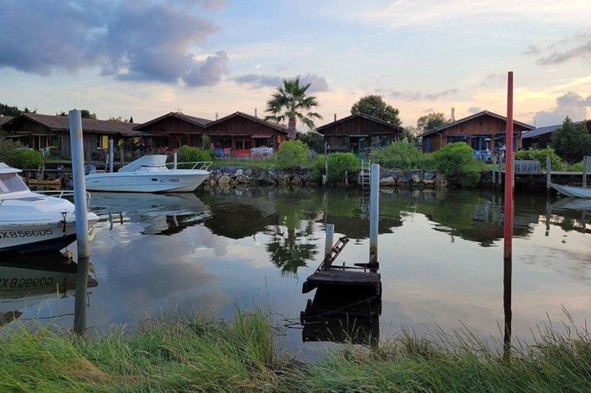 Una marina con barcos amarrados, agua tranquila y edificios de madera al fondo. 5