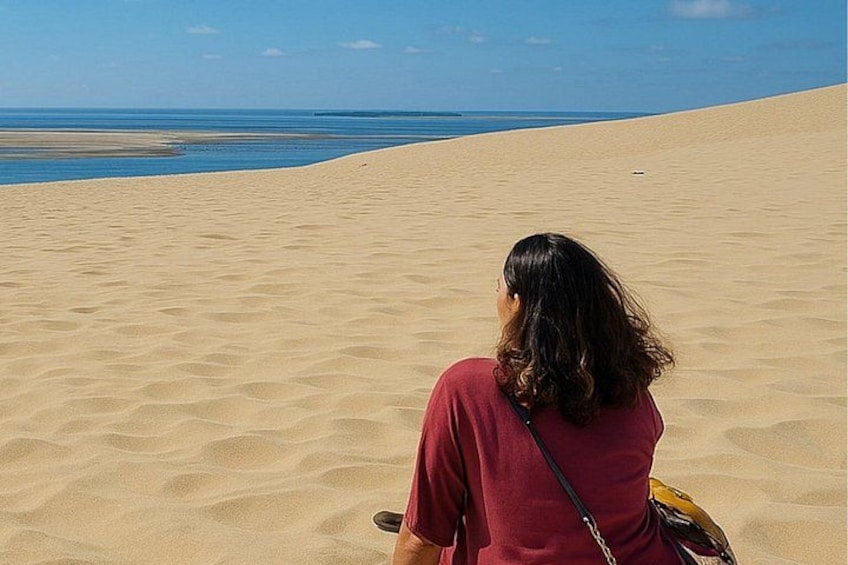 Una persona caminando sobre una playa arenosa bajo un cielo despejado. 1