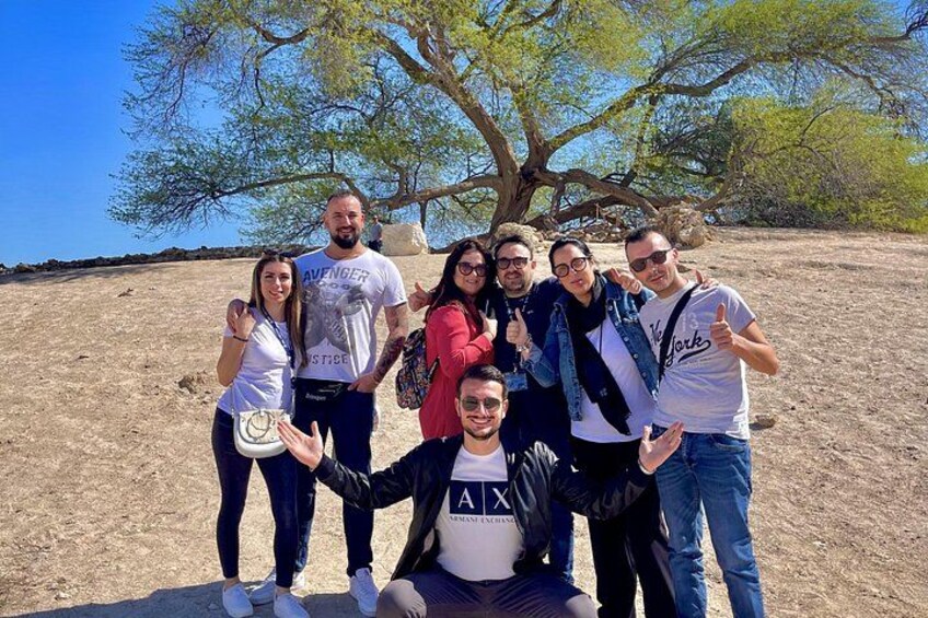 A group of people posing outdoors with a large tree in the background. 1