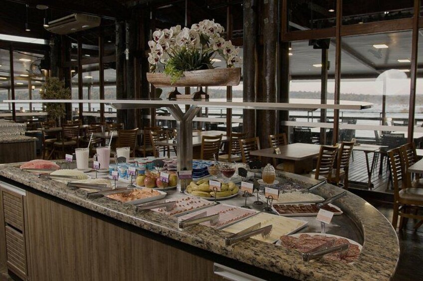 Un mostrador de buffet con diversos alimentos y un arreglo floral. 3