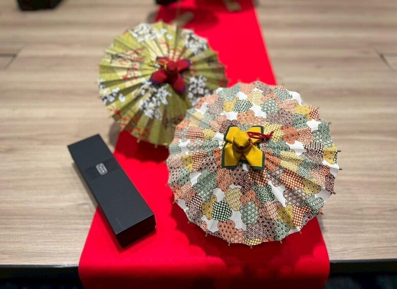 Two decorative umbrellas with colorful patterns and bows on a red surface. 5
