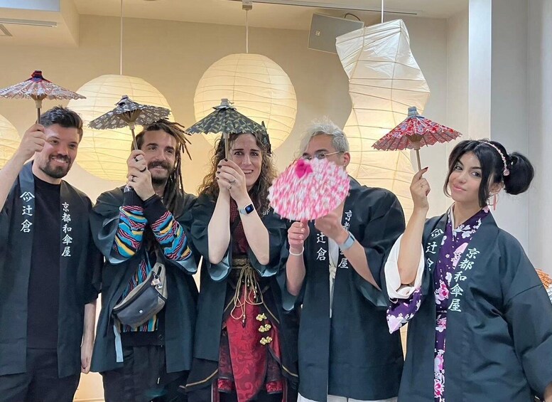 A group of people holding umbrellas in a modern building with large windows and decorative paper lanterns. 1