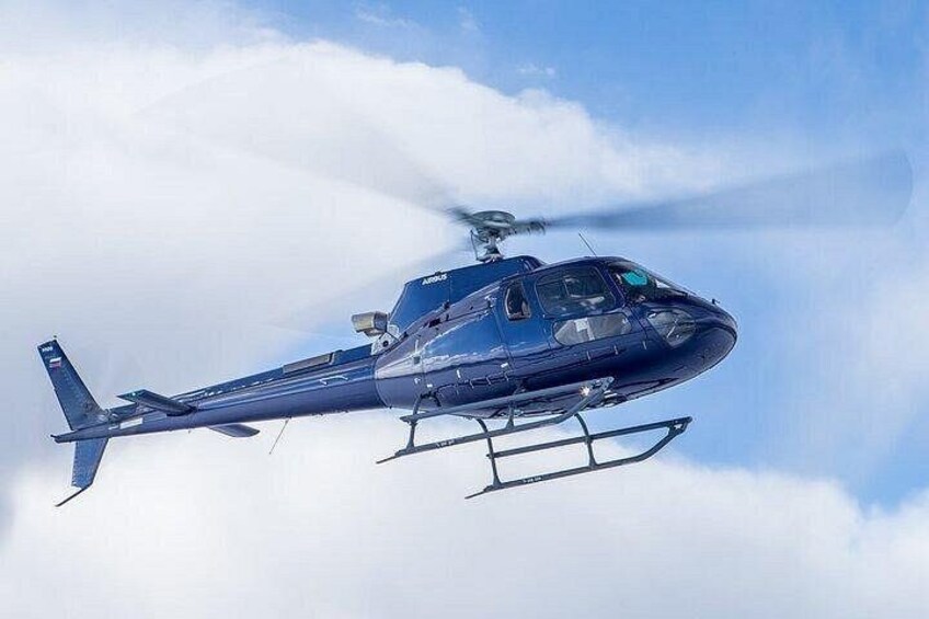 En blå helikopter flyver hen over himlen. 1