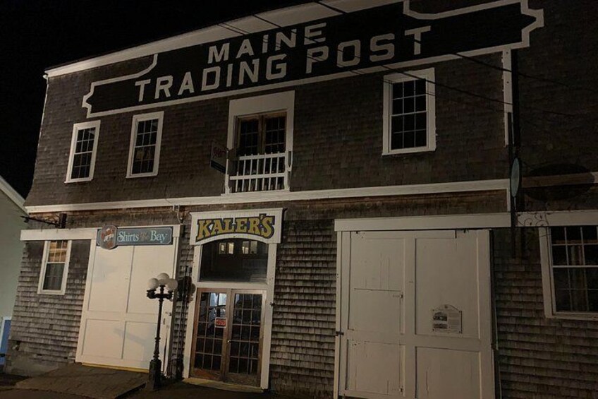 Ein Gebäude mit einem Schild, das 'MAINE TRADING POST' und ein weiteres Schild für 'Shirts & Bay' zeigt. 4