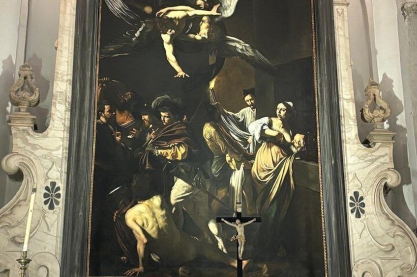 A classical painting with a central figure on a cross, flanked by other figures in dynamic poses, framed by ornate architectural details. 1