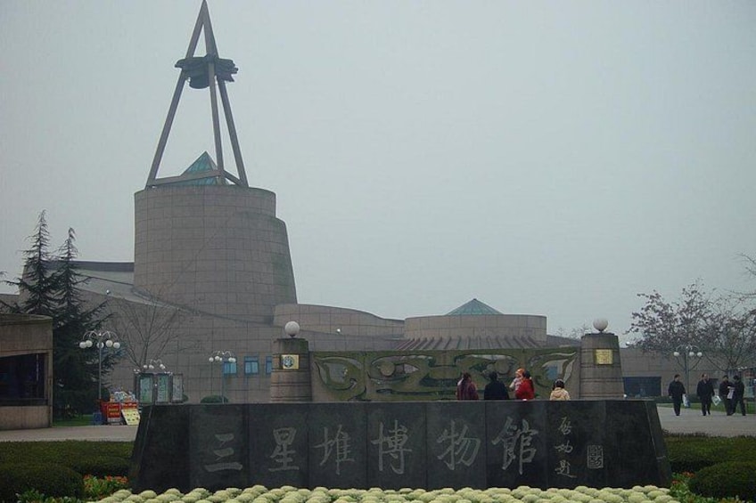 A building with a unique triangular tower and a sign with Chinese characters. 3