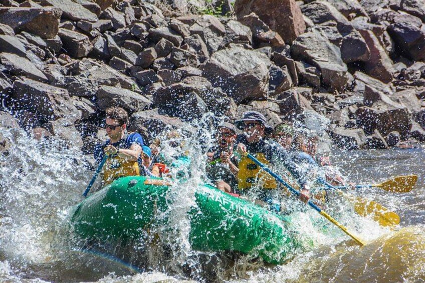A group of people kayaking on a river surrounded by rocks. 1