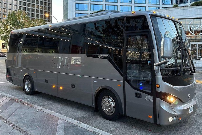 En stor, modern buss med "STAR"-logotypen på, parkerad på en gata i staden. 2