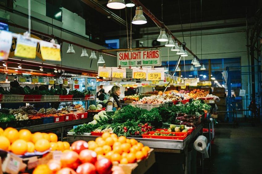 En mataffär med färska grönsaker och ett skylt för Sunlight Farms. 4