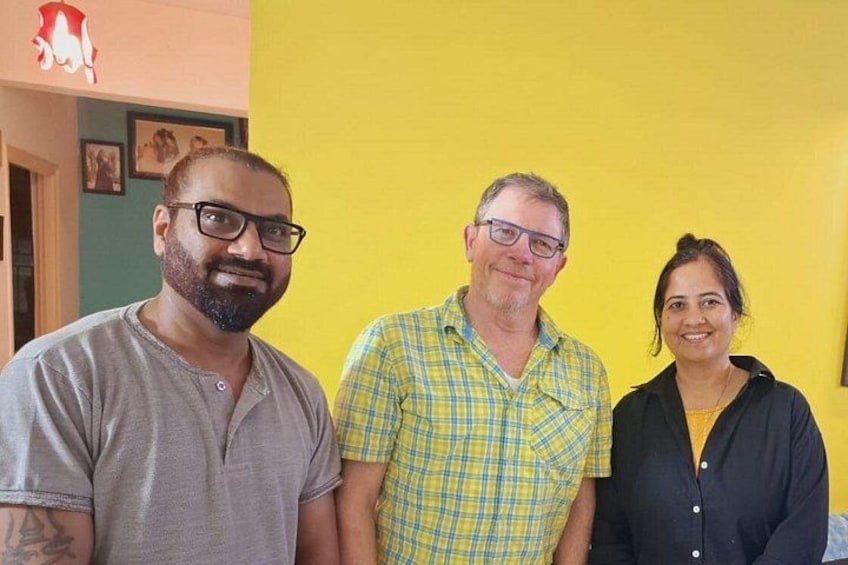 Three people standing in a room with yellow walls. 3