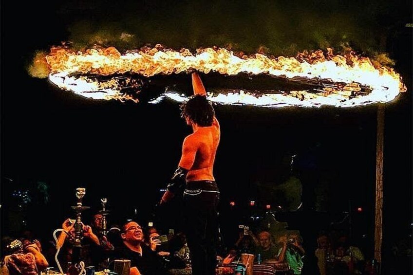 A performer balancing a flaming hoop. 4