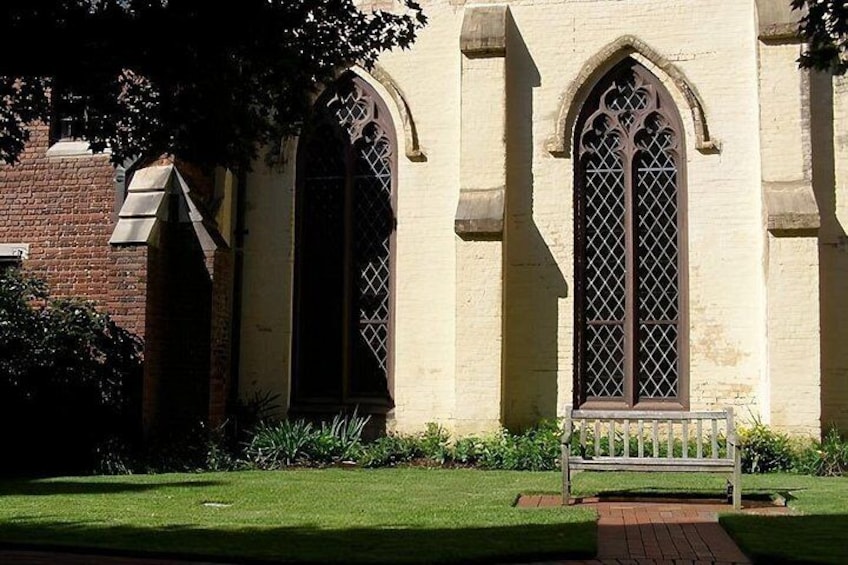 A building with arched windows and a bench in front. 2