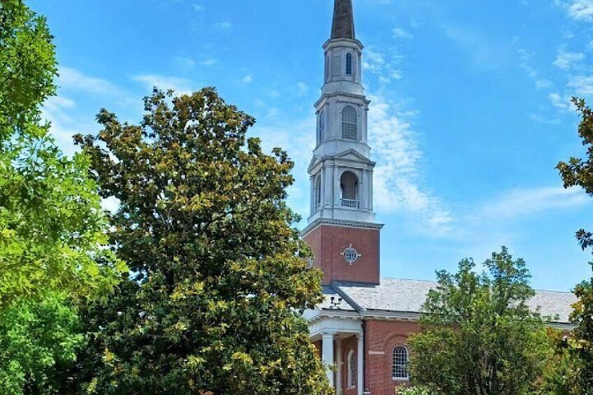 A church with a tall steeple, surrounded by trees. 3